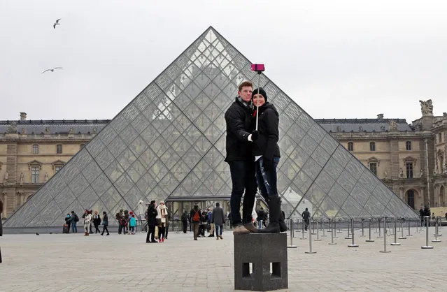 Chris Baker and Jennifer Hinson from Nashville, Tennessee, use a selfie stick in front of the Louvre Pyramide in Paris, Tuesday, January 6, 2015January 6, 2015. (Photo by Remy de la Mauviniere/AP Photo)