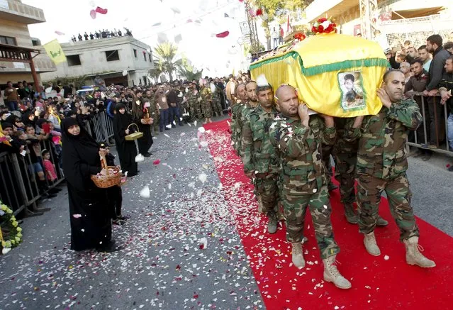 Muslim women toss rose petals as Lebanon's Hezbollah members carry the coffin of their comrade, Ali Tnana, who was killed fighting alongside Syrian army forces in Syria, during his funeral in Saksakieh village, southern Lebanon, November 27, 2015. (Photo by Ali Hashisho/Reuters)