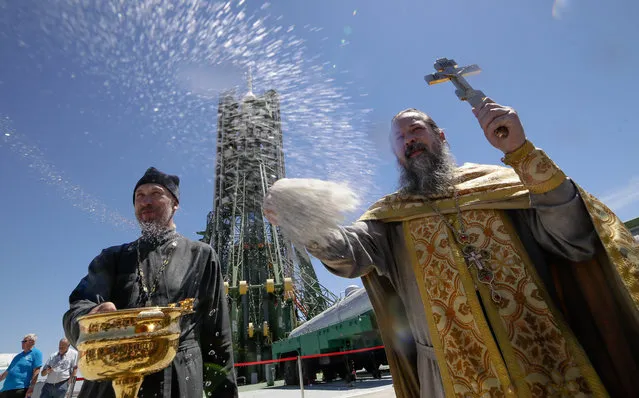 An Orthodox priest conducts a blessing service in front of the Soyuz FG rocket at the Russian leased Baikonur cosmodrome, Kazakhstan, Tuesday, June 5, 2018. The new Soyuz mission to the International Space Station (ISS) is scheduled on Wednesday, June 6, with U.S. astronaut Serena Aunon-Chancellor, Russian cosmonaut Sergey Prokopyev, and German astronaut Alexander Gerst. (Photo by Dmitri Lovetsky/AP Photo)