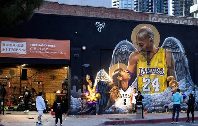 People stop by a mural of late Kobe Bryant, who died one year ago alongside his daughter and seven others when their helicopter crashed into a hillside, in Los Angeles, California, January 26, 2021. (Photo by Mario Anzuoni/Reuters)