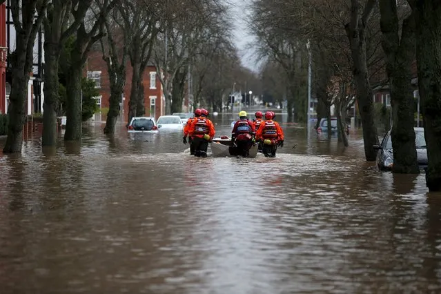 Rescue workers are seen helping locals during flooding caused by heavy rainfall in the Warwick Road area of Carlisle, Britain December 6, 2015. (Photo by Phil Noble/Reuters)
