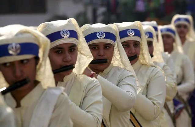 Sikh girls play flutes as they take part in a religious procession on the eve of the 546th birth anniversary of Guru Nanak Dev, the first Sikh Guru and founder of Sikh faith, in Amritsar, India, November 24, 2015. (Photo by Munish Sharma/Reuters)