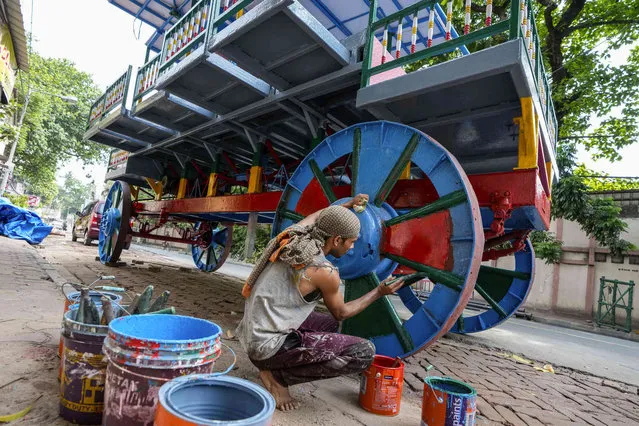 A worker paints a wheel of a chariot ahead of Chariot festival in Kolkata, India, Friday, June 16, 2023. (Photo by Bikas Das/AP Photo)