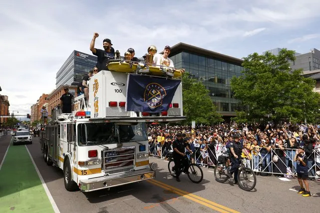 Jamal Murray #27 and Nikola Jokic #15 wave to fans with the Larry O'Brien Championship Trophy during the Denver Nuggets victory parade and rally after winning the 2023 NBA Championship on June 15, 2023 in Denver, Colorado. (Photo by Justin Edmonds/Getty Images)