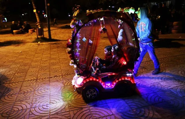 Palestinian children ride an electronic toys car while touring at the main square in Gaza City, Thursday, December 17, 2015. (Photo by Adel Hana/AP Photo)