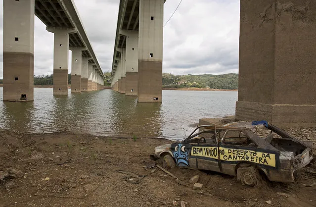 The frame of a car with a text that reads in Portuguese “Welcome to the desert of Cantareira”, written on its side, is revealed by the receding waters of the Atibainha reservoir, part of the Cantareira System that provides water to the Sao Paulo metropolitan area, in Nazare Paulista, Brazil, Thursday, January 29, 2015. (Photo by Andre Penner/AP Photo)