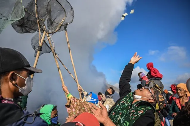 Members of the Tengger sub-ethnic group gather to present offerings at the crater's edge of the active Mount Bromo volcano as part of the Yadnya Kasada festival in Probolinggo, East Java province on June 5, 2023. (Photo by Juni Kriswanto/AFP Photo)