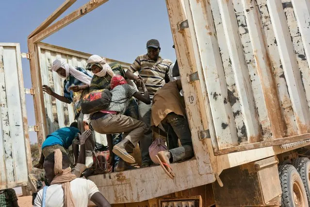 Migrants climb into a truck to head north into Algeria at the Assamaka border post in northern Niger on Sunday, June 3, 2018. The International Organization for Migration has estimated that for every migrant known to have died crossing the Mediterranean, as many as two are lost in the desert. (Photo by Jerome Delay/AP Photo)