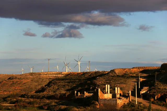 Windmills are seen behind the ruins of the old village of Belchite, in northern Spain, November 13, 2016. (Photo by Andrea Comas/Reuters)