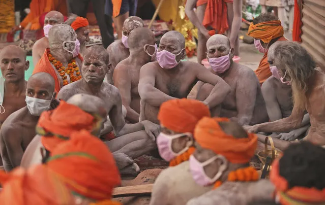 Naga Sadhu or Naked Hindu holy men wait for the start of a procession towards the river Ganges for Shahi snan or a Royal bath during Kumbh mela, in Haridwar in the Indian state of Uttarakhand, Monday, April 12, 2021. (Photo by Karma Sonam/AP Photo)