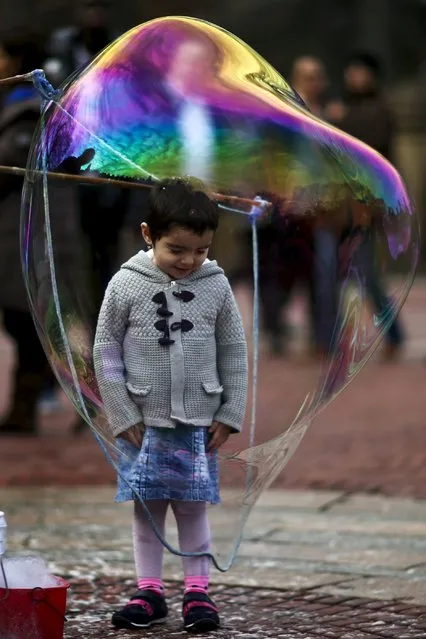 A child goes inside a bubble during a warm day in Central Park, New York December 25, 2015. (Photo by Eduardo Munoz/Reuters)