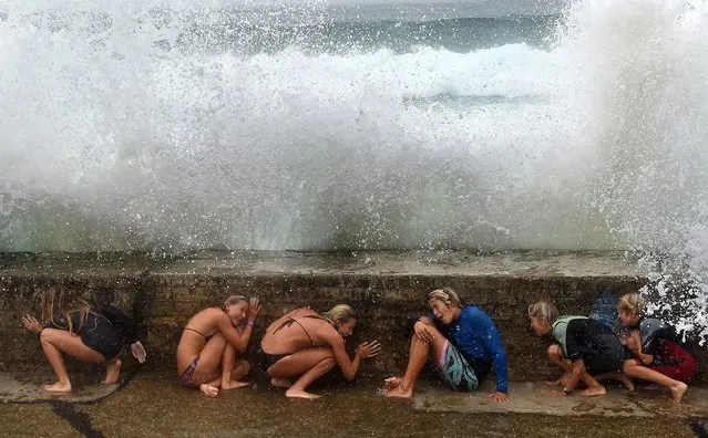 Young people play with big sea waves due to the Tropical Cyclone Marcia, on the Gold Coast, Queensland, Australia, 20 February 2015. (Photo by Dave Hunt/EPA)