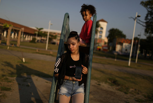 On the morning of April 8, 12-year-old Eduarda Lopes watched as her mother, Valdilene da Silva, was shot by a stray bullet in Rio de Janeiro's Manguinhos slum, one of the countless innocent victims of rising gangland violence in the city. As she lay dying in a puddle of blood, Silva used her last breaths to tell her daughter to run and hide. But despite her fear of being killed, Lopes stayed with her mother. “I waited with her until the final moment, by her side”, Lopes told Reuters, as tears streamed down her face. “I couldn't bear it”, Lopes said, of when she got to see her mother's corpse later that day. “I saw her lying there and she looked like a doll, asleep. The only thing I could take with me were the earrings she was wearing”. Brazil's violence is spiking and ever more victims are caught in the crossfire of gangs warring with each other or police. Rio de Janeiro state registered over 4,500 murders during the first eight months of 2018, up 6 percent compared with the same period in 2017. More than 1,000 people died in confrontations with police in the state between January and August, official data shows, up over 50 percent on the same period in 2017. Authorities say those killed are mostly suspected drug gang members, while critics allege innocent people are also slain. Here: Eduarda Lopes, 12, poses for a photograph as she holds up a picture of her mother on her phone in the Manguinhos slum in Rio de Janeiro, Brazil, September 13, 2018. Lopes's mother, Valdilene da Silva, was killed in crossfire as they walked together. (Photo by Pilar Olivares/Reuters)