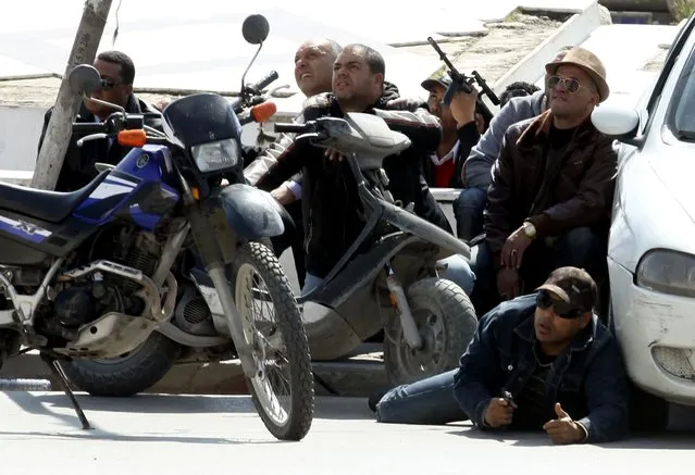 Police officers are seen on the pavement outside parliament in Tunis March 18, 2015. Gunmen attacked Tunisia's national museum near its parliament on Wednesday, killing at least seven tourists and taking others hostage inside the building, the government said. (Photo by Zoubeir Souissi/Reuters)