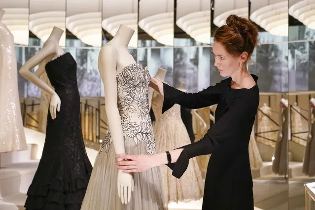 A curator adjusts a creation which is displayed as part of the “Gabrielle Chanel. Fashion Manifesto” exhibition at the Victoria and Albert museum, in London, Tuesday, September 12, 2023. (Photo by Alberto Pezzali/AP Photo)