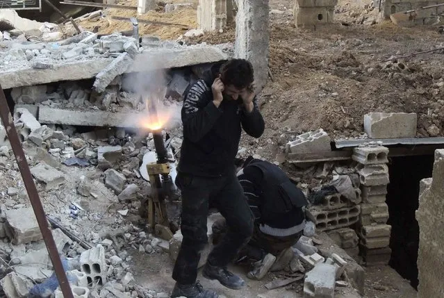 Rebel fighters from the Free Syrian Army's Al Rahman legion fire a mortar at the frontline against forces loyal to Syria's President Bashar al-Assad in Jobar, a suburb of Damascus January 28, 2015. (Photo by Yousef Homs/Reuters)