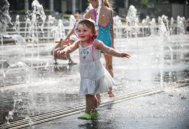 People cool off in a fountain during a hot summer day in Moscow on June 24, 2021. Moscow has been hit by a historic heat wave this week, with temperatures reaching a 120-year record due to the effects of climate change. On Monday the Russian capital sweated under 34.7 degrees Celsius (94.5 degrees Fahrenheit), according to Roshydromet, matching the record for a June day from in 1901. The weather service, which has kept records since 1881, is forecasting temperatures above 35 degrees Celsius (95 degrees Fahrenheit) on Thursday and Friday. (Photo by Alexander Nemenov/AFP Photo)