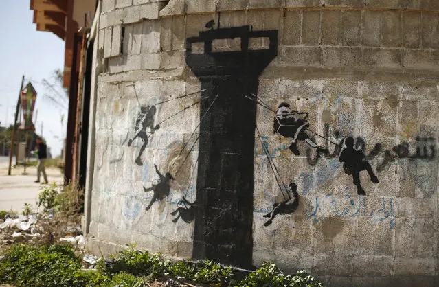 A mural, presumably painted by British street artist Banksy, is seen on a wall in Biet Hanoun town in the northern Gaza Strip February 26, 2015. (Photo by Suhaib Salem/Reuters)