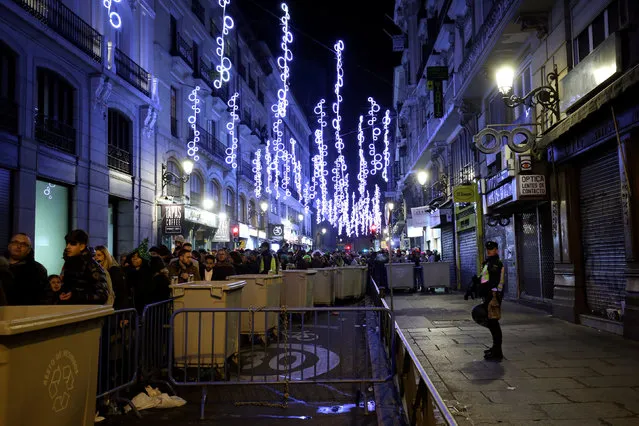 People wait in line to go through a security check before the start of New Year's celebrations at Puerta del Sol square in central Madrid, Spain December 31, 2016. (Photo by Susana Vera/Reuters)