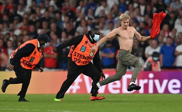 Fan invades the pitch during the match Italy v England as stewards attempt to tackle him at Wembley Stadium in London, Britain on July 11, 2021. (Photo by Paul Ellis/Reuters)