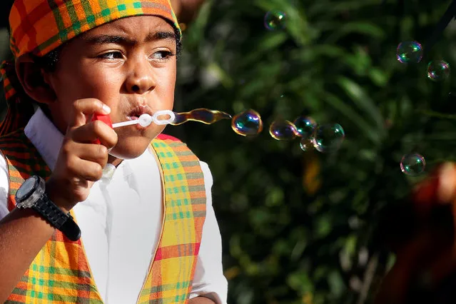 A child blows bubbles in Prince Harry's face as he attends a charity event during his official visit in St. John's, Antigua, November 21, 2016. (Photo by Carlo Allegri/Reuters)
