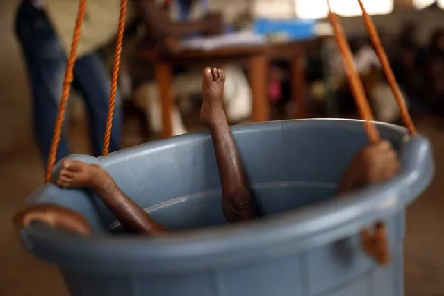 A young child lays in a bucket being  weighed by nurses in Bangui, Central African Republic,  Thursday February 11, 2016. The U.N. World Food Program estimates that nearly half the country – 2.5 million people – are facing hunger as  more than two years of violence has severely disrupted the country’s agriculture and health care sectors. Two former prime ministers, Touadera and  Anicet Georges Dologuele, are running neck-and-neck in the second round of presidential elections Sunday Feb. 14  to end years of violence pitting Muslims against Christians in the Central African Republic. (Photo by Jerome Delay/AP Photo)