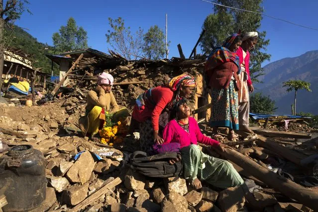 A woman cries near the earthquake damaged house where her son, daughter in law and grand child died in  Jajarkot district, northwestern Nepal, Sunday, November 5, 2023. (Photo by Niranjan Shrestha/AP Photo)
