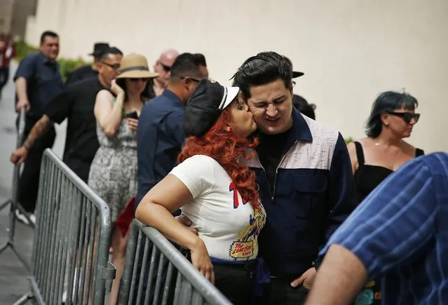 In this April 5, 2015, photo, Angie Almilla kisses Eric Martinez while waiting in line for a pool party at the Viva Las Vegas Rockabilly Weekend in Las Vegas. The event included fashion shows, dance lessons and contests set against a backdrop of rock 'n' roll and pre-1963 classic cars. (Photo by John Locher/AP Photo)