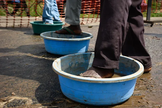 People from Democratic Republic of Congo (DRC) disinfect their feet at the Ebola screening point bordering with DRC in Mpondwe, western Uganda, on December 12, 2018. The second largest Ebola outbreak in Africa has strated in Democratic Republic of Congo causing 298 deaths since August 2018, according to the World Health Organization (WHO). (Photo by Isaac Kasamani/AFP Photo)