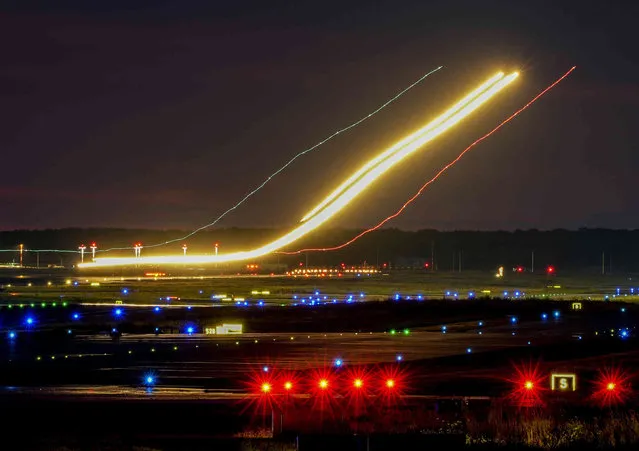 A long camera exposure photo shows an aircraft approaching to land at the international airport in Frankfurt, Germany, Monday, August 9, 2021. (Photo by Michael Probst/AP Photo)