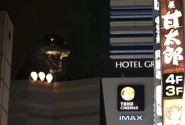 A real-scale head of Godzilla is displayed at the balcony of a newly-built commercial complex as a new Tokyo landmark during its unveiling at Kabukicho shopping and amusement district in Tokyo April 9, 2015. (Photo by Issei Kato/Reuters)