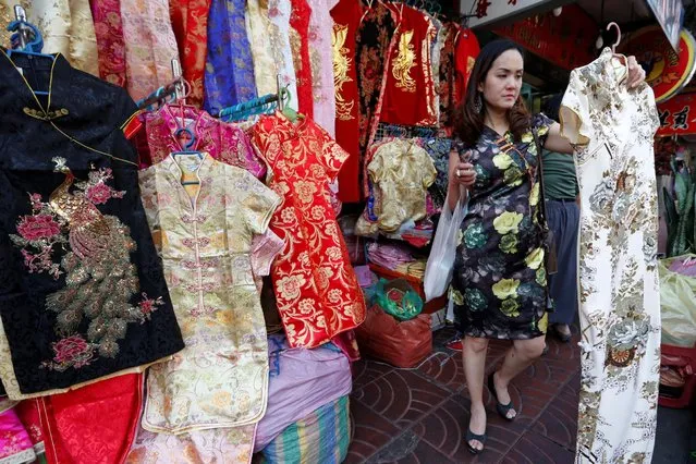 A Thai woman buy clothes to celebrate Chinese New Year in Chinatown in Bangkok, Thailand January 24, 2017. (Photo by Chaiwat Subprasom/Reuters)