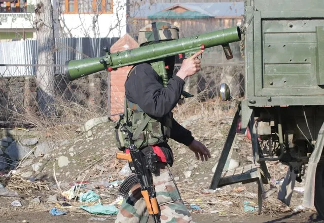 An Indian Army soldier carries a rocket launcher near the site of a gun battle between suspected militants and Indian security forces in Pinglan village in south Kashmir's Pulwama district February 18, 2019. (Photo by Younis Khaliq/Reuters)