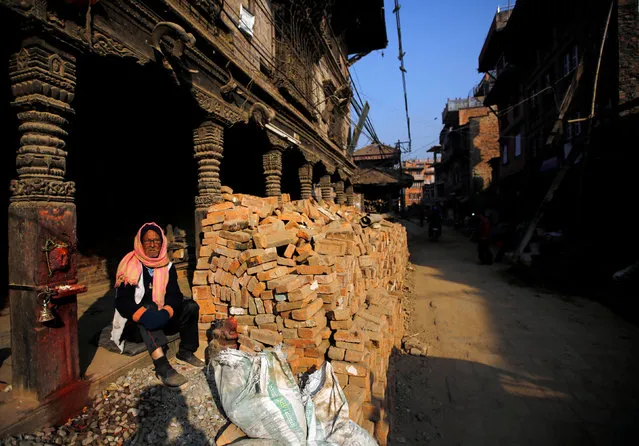 A man basks in the sun as he sits near a pile of bricks collected from the houses collapsed during the 2015 earthquake, in Bhaktapur, Nepal January 10, 2017. (Photo by Navesh Chitrakar/Reuters)