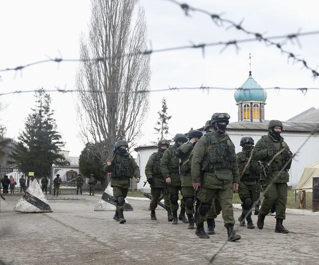 Uniformed men, believed to be Russian servicemen, march outside a Ukrainian military base in the village of Perevalnoye outside Simferopol, March 5, 2014. (Photo by Vasily Fedosenko/Reuters)