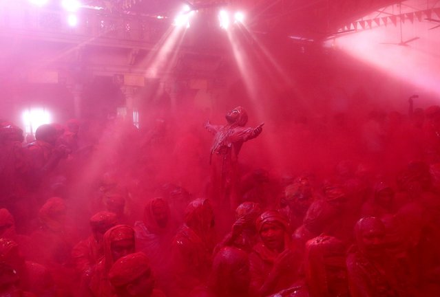 Hindu men from the village of Nandgaon celebrate covered with colored powder the Lathmar Holi festival at the Radha Rani temple in Barsana village, Mathura, India, 06 March 2017. Holi is the Hindu spring festival of colors. In Barsana, people celebrate a variation of holi, called “Lathmar” Holi, which means “beating with sticks”. During the Lathmar Holi festival, the women of Barsana, the birth place of Hindu God Krishna's beloved Radha, beat the men from Nandgaon, the hometown of Hindu God Krishna, with wooden sticks in response to their efforts to throw color on them. (Photo by Rajat Gupta/EPA)
