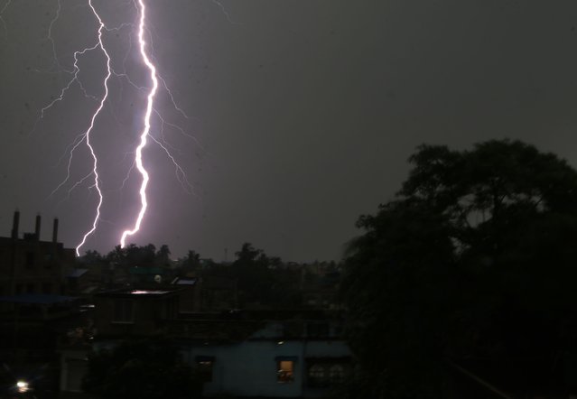 This photograph taken on April 27, 2023 shows a lightning strike  near the resident balling  during a thunderstorm over the city of Kolkata in India. (Photo by Debajyoti Chakraborty/NurPhoto)