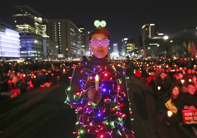 A protester wearing electric lights attached to his clothing attends a rally calling for impeached President Park Geun-hye's arrest in Seoul, South Korea, Friday, March 10, 2017. The Constitutional Court removed impeached President Park Geun-hye from office in a unanimous ruling Friday over a corruption scandal that has plunged the country into political turmoil and worsened an already-serious national divide. (Photo by Ahn Young-joon/AP Photo)