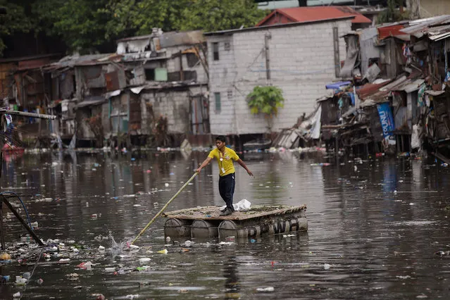 A man navigates a raft along a polluted canal in Manila, Philippines Monday, March 20, 2017. Many people living beside the city's waterways dispose their garbage in the canals clogging up portions of them especially during the rainy season where flood normally occurs. (Photo by Aaron Favila/AP Photo)