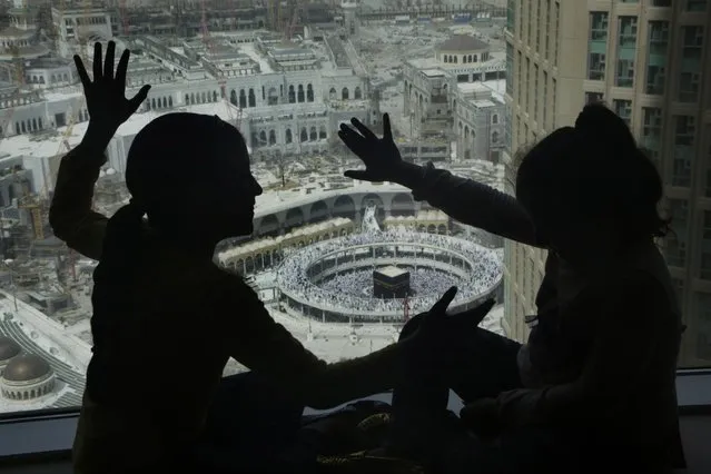 Children play at the glass windows of a hotel overlooking the Grand Mosque, in the Muslim holy city of Mecca, Saudi Arabia, Friday, March 11, 2016. (Photo by Amr Nabil/AP Photo)