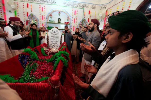 Men say a prayer over the grave of Mumtaz Qadri at the shrine built over his grave outside Islamabad, Pakistan, February 28, 2017. (Photo by Faisal Mahmood/Reuters)