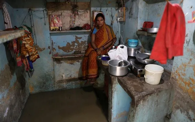 A woman eats inside her flooded house on the banks of the river Yamuna in Delhi, India, August 20, 2019. (Photo by Anushree Fadnavis/Reuters)