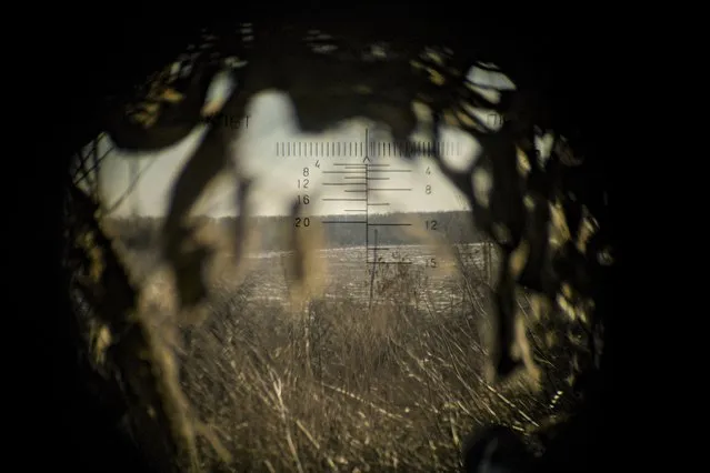 Land is seen through a machine gun spotting optic, outside Popasna, Luhansk region, eastern Ukraine, Monday, February 14, 2022. Russia's Foreign Minister Sergey Lavrov advised President Vladimir Putin on Monday to keep talking with the West on Moscow's security demands, a signal from the Kremlin that it intends to continue diplomatic efforts amid U.S. warnings of an imminent Russian invasion of Ukraine. (Photo by Vadim Ghirda/AP Photo)