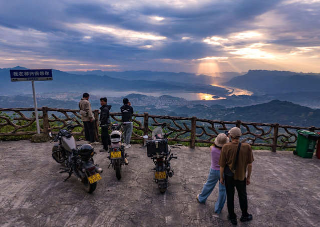 Tourists are watching the sunrise from a viewing platform on the Three Gorges Dam in Yichang, China, on June 23, 2024. (Photo by Costfoto/NurPhoto/Rex Features/Shutterstock)
