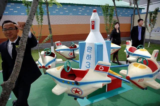 Officials accompanying foreign reporters stand near a rocket themed marry-go-around at kindergarden of a factory reporters visit on a government organised tour in central Pyongyang, North Korea May 9, 2016. (Photo by Damir Sagolj/Reuters)