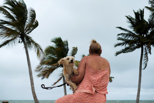 A woman holds her dog as she surveys the water as Tropical Storm Karen approaches in Yabucoa, Puerto Rico on September 24, 2019. (Photo by Ricardo Arduengo/Reuters)
