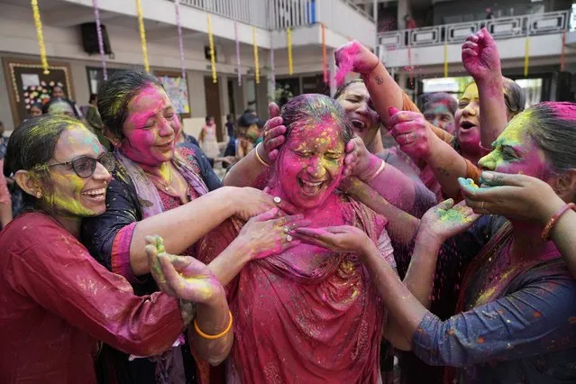 Teachers apply colored powder on another as they celebrate Holi, the Hindu festival of colours, at a school in Ahmedabad, India, Thursday, March 17, 2022. (Photo by Ajit Solanki/AP Photo)