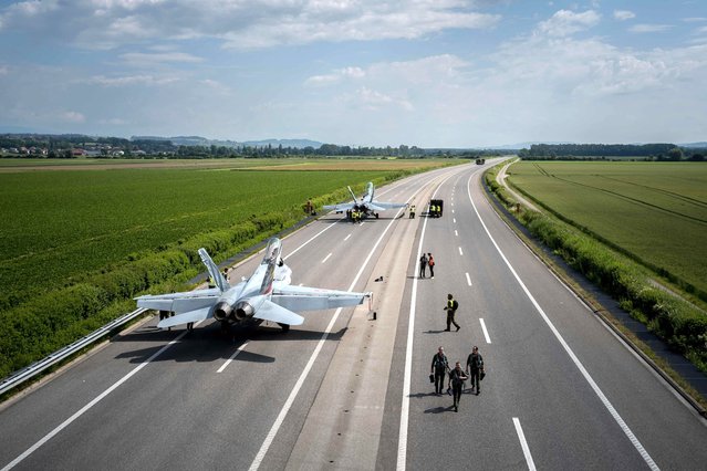 F/A-18 fighter jets are seen after landing during tests of Swiss Air force for take-offs and landings of fighter jets on the A1 motorway between Avenches and Payerne, western Switzerland, on June 5, 2024, with the aim of testing and expanding the ability to decentralise their air defence resources. (Photo by Fabrice Coffrini/AFP Photo)