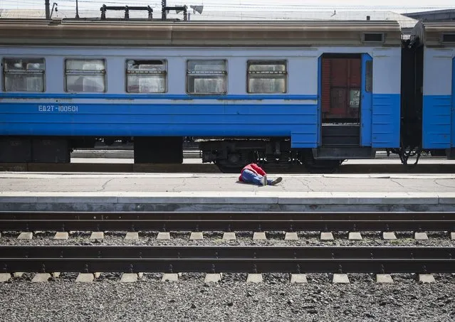A casualty lies on the platform in the aftermath of a rocket attack on the railway station in the eastern city of Kramatorsk, in the Donbass region on April 8, 2022. (Photo by Anatolii Stepanov/AFP Photo)
