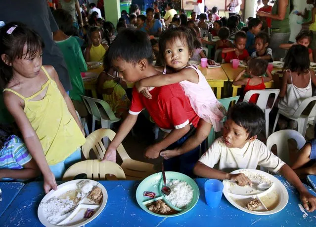 Children eat their free meals during a feeding program by outreach group World Mission Community Care at a slum area in Tondo city, metro Manila, July 20, 2015. Hunger in the Philippines decreased to its lowest level in 10 years as a recent survey showed a drop to 12.7 percent of families that were going hungry, or around 2.8 million households, in the second quarter of 2015, according to a poll by non-profit social research institution Social Weather Stations (SWS). (Photo by Romeo Ranoco/Reuters)